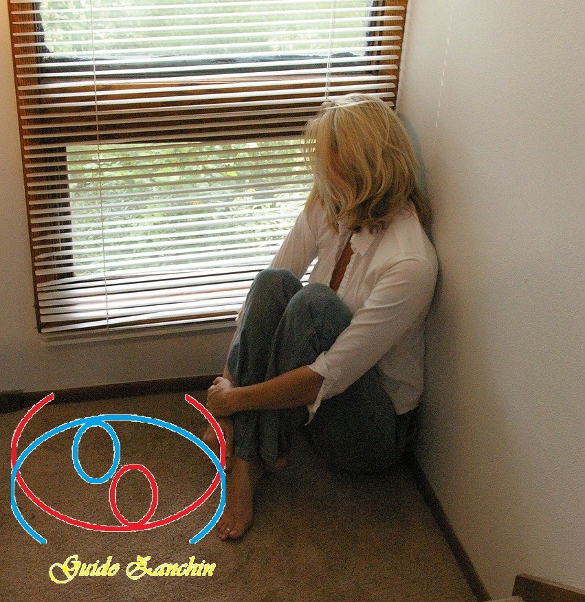 donna seduta, rannicchiata, triste